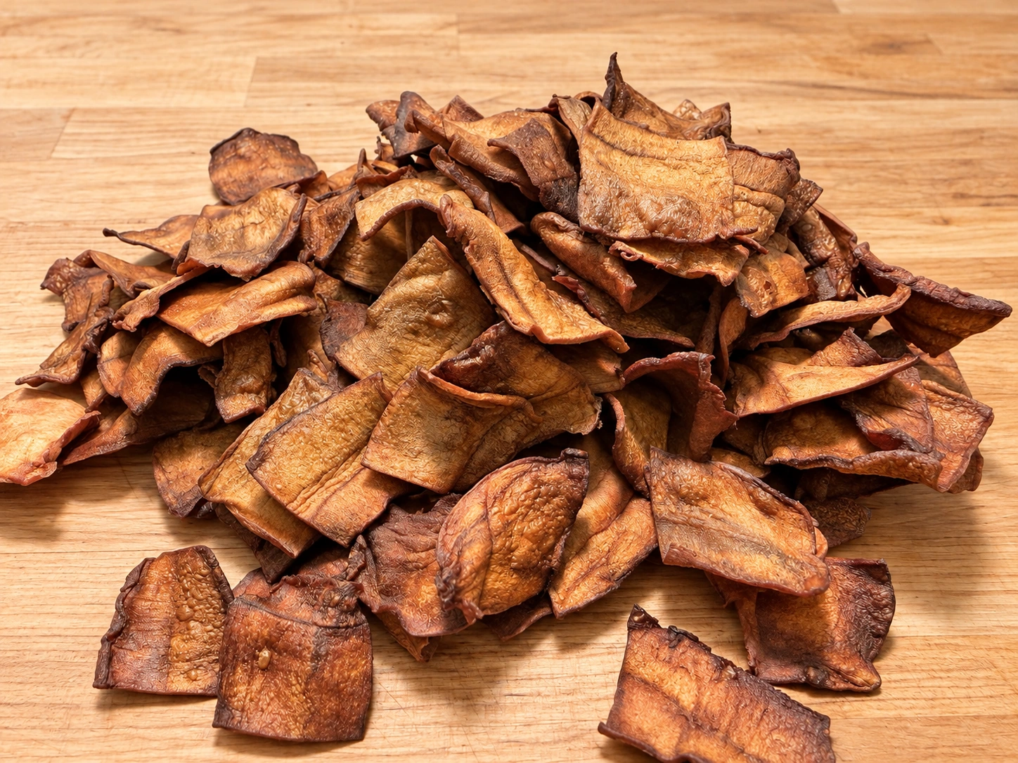 Golden MyChips with curled, crisp edges on a wooden counter